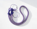 Purple snake print Bubzi camera strap with metal carabiners on a white background