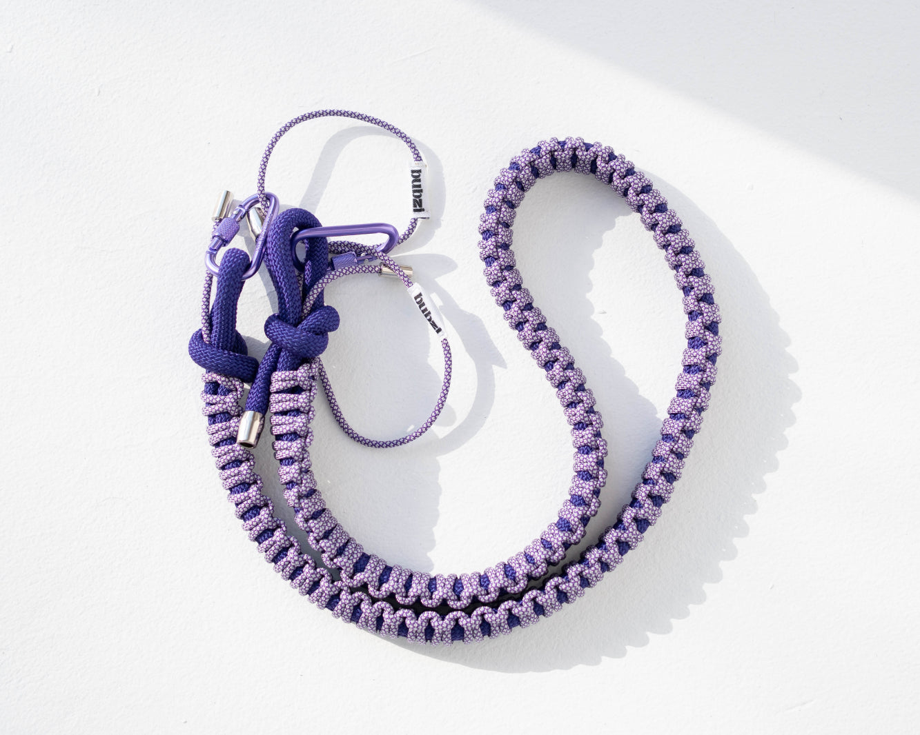 Purple snake print Bubzi camera strap with metal carabiners on a white background