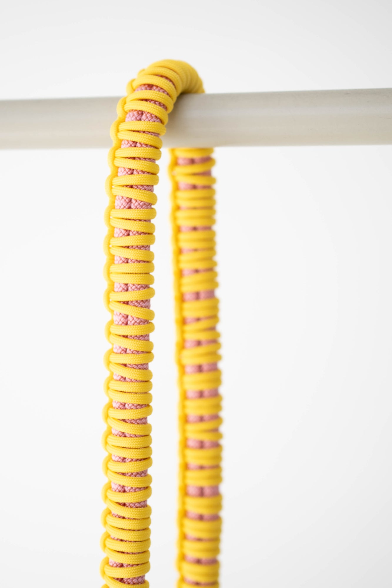 Close-up of the yellow and pink paracord weave on the Bubzi camera strap