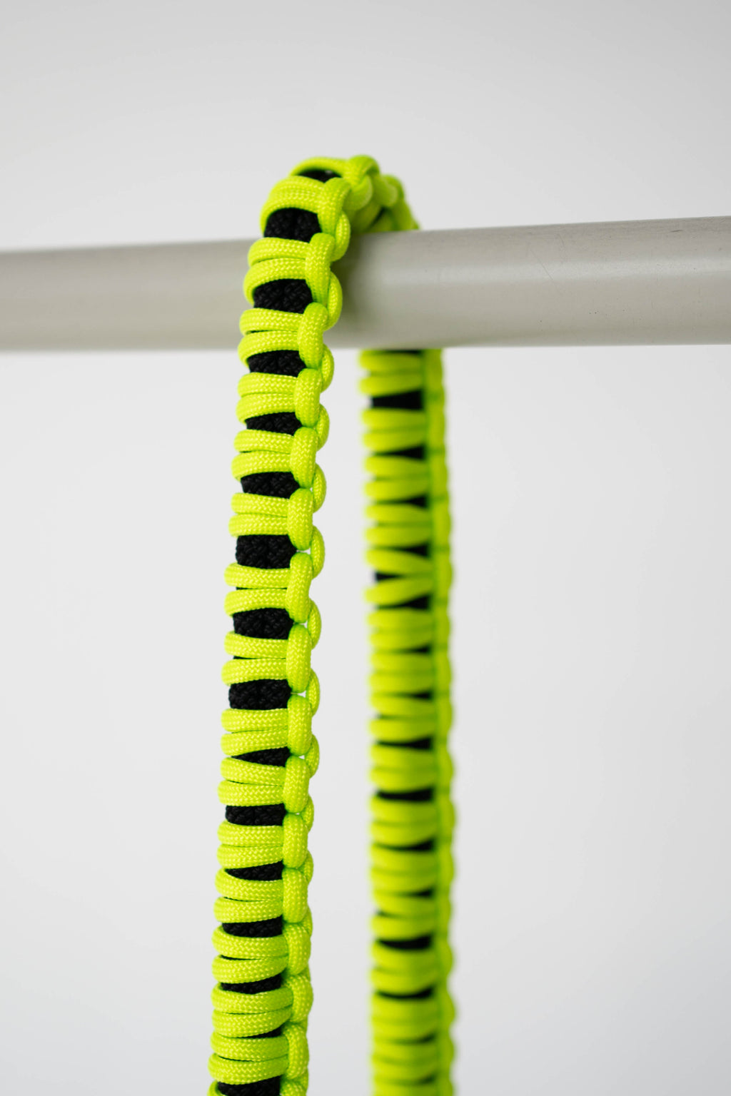 Model holding a camera with the black and lime Bubzi camera strap in a studio