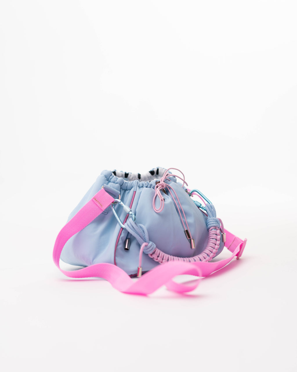 Side view of the blue Mini Bubzi bag with pink shoulder strap and soft rounded shape
