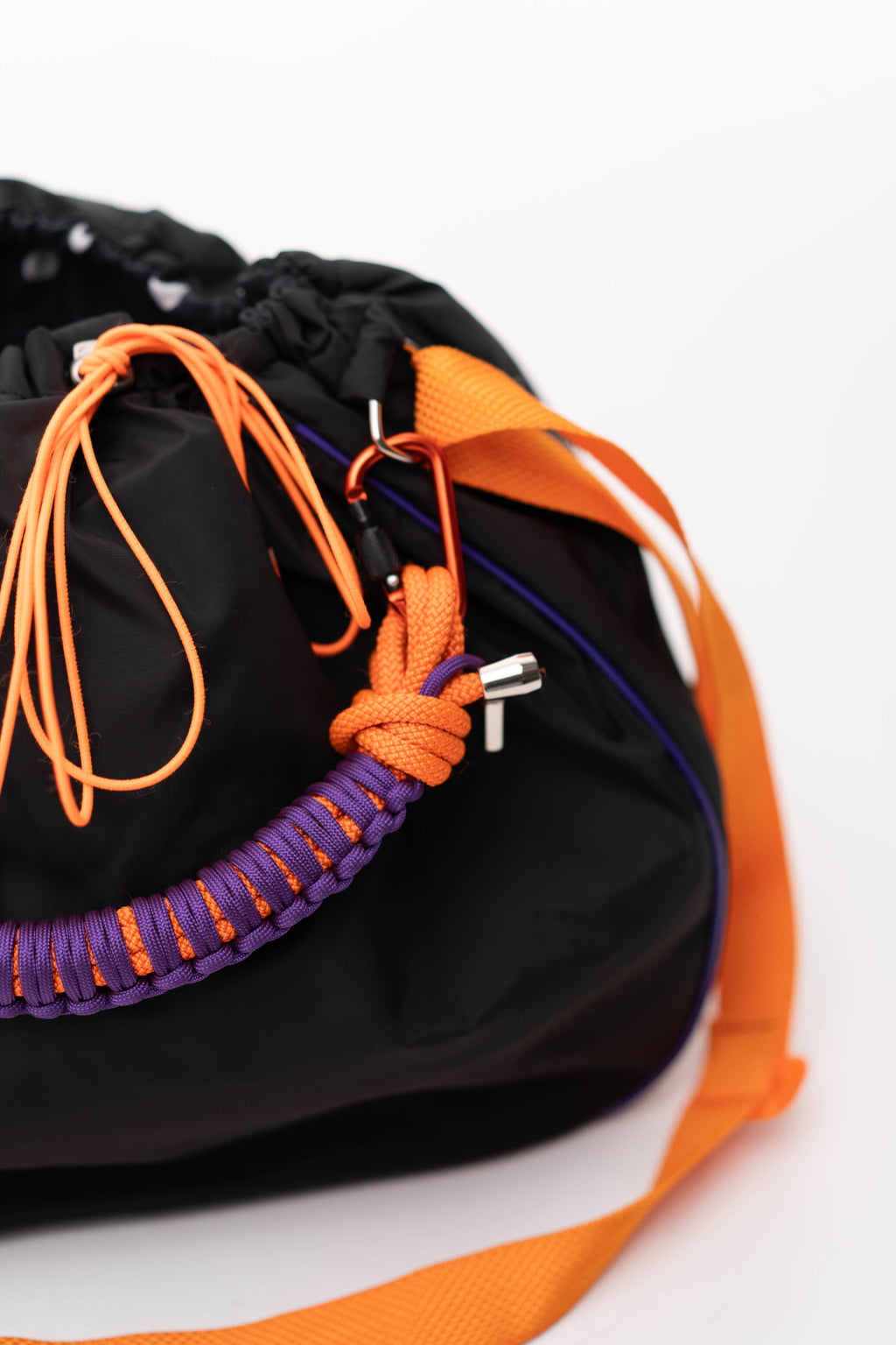 Close-up of the black Maxi Bubzi bag with orange drawstrings, purple handle, and soft polka dot lining