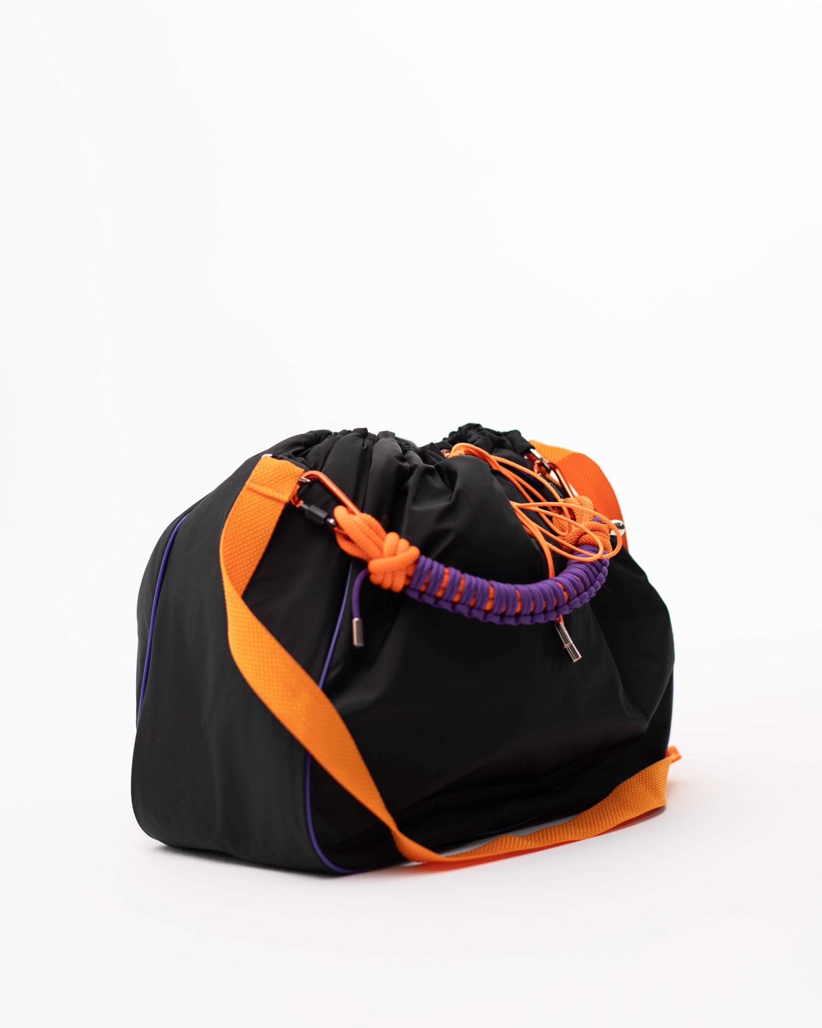 Side view of the black Maxi Bubzi bag with orange shoulder strap and purple braided handle