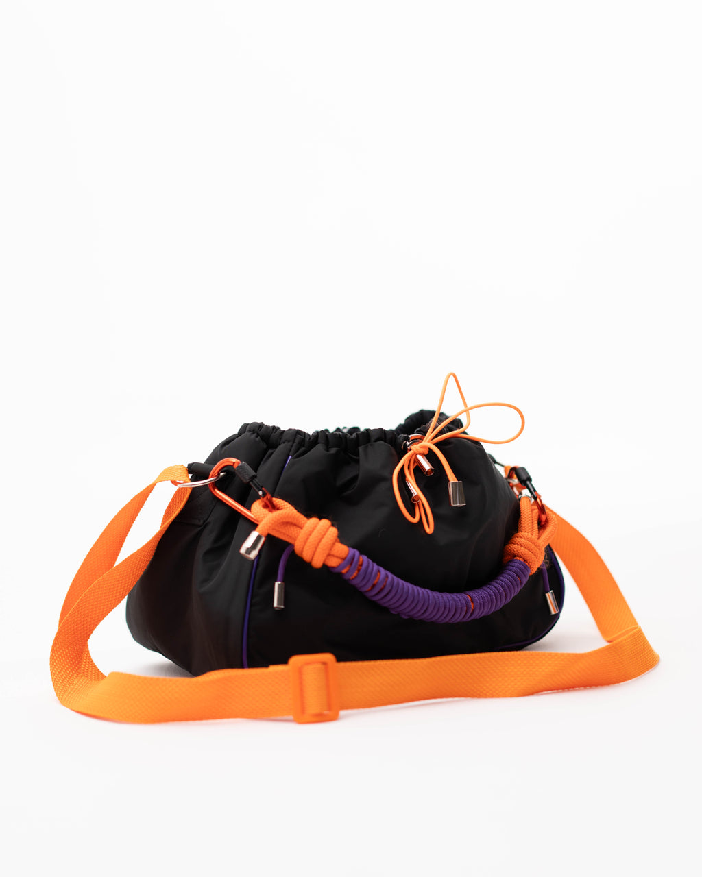 Detail view of the black Mini Bubzi bag with side attachment, orange strap, and braided handle