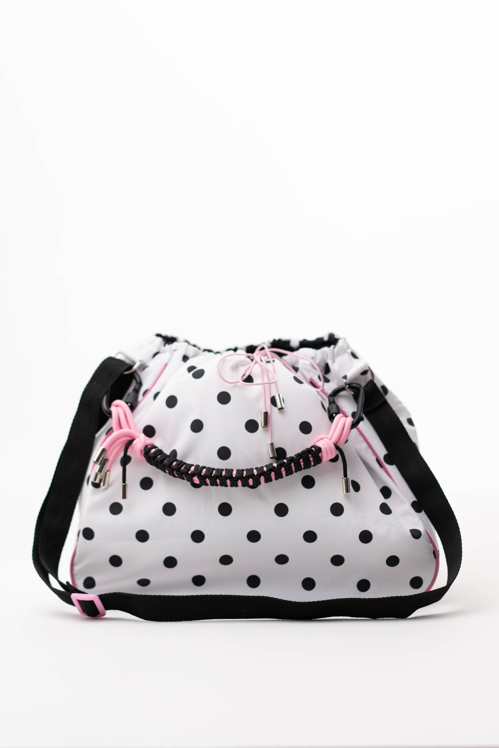 Polka dot Maxi Bubzi bag with pink details and a braided handle against a white background.