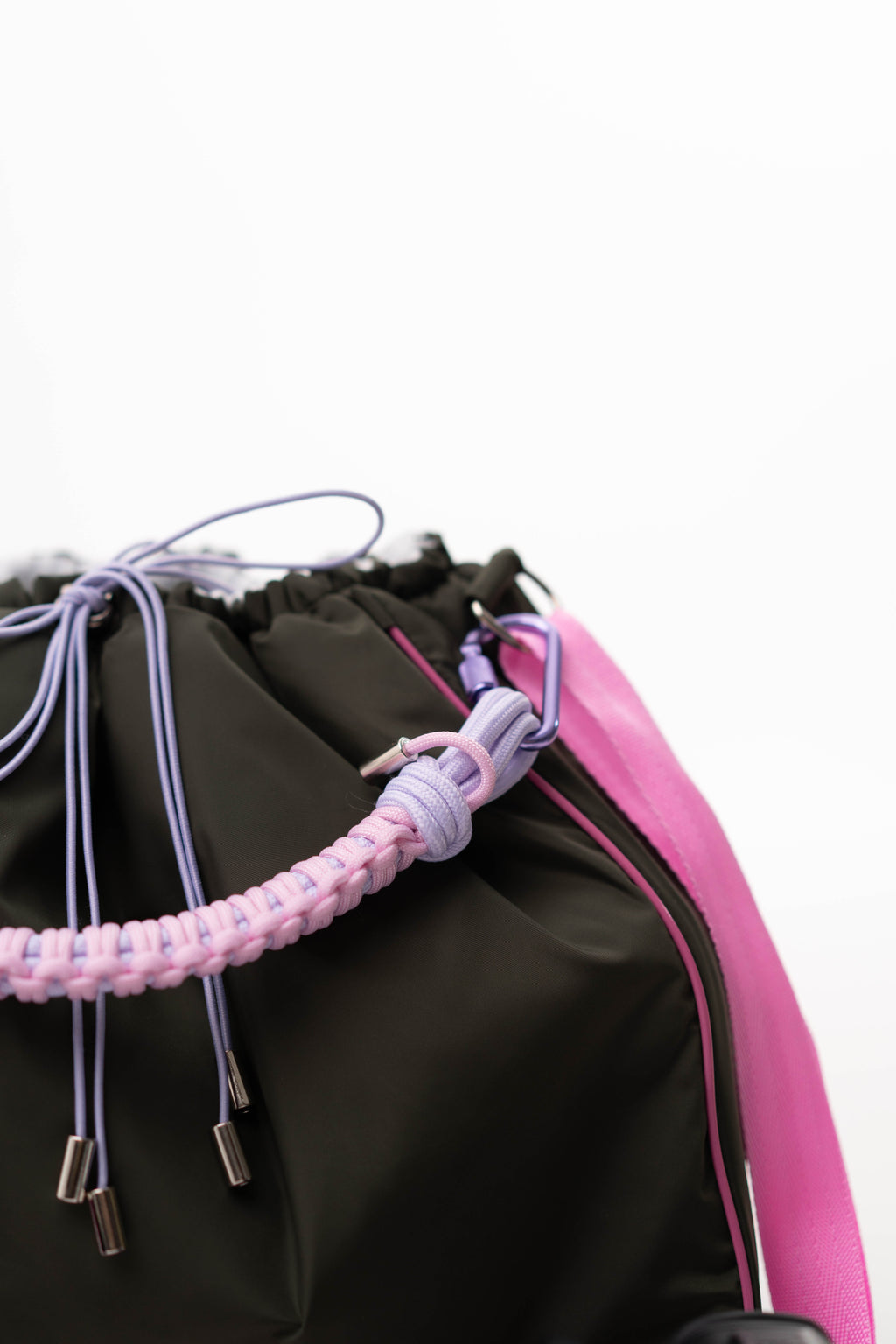 Close-up of the khaki Maxi Bubzi bag with a pink handle, purple drawstrings, and shoulder strap