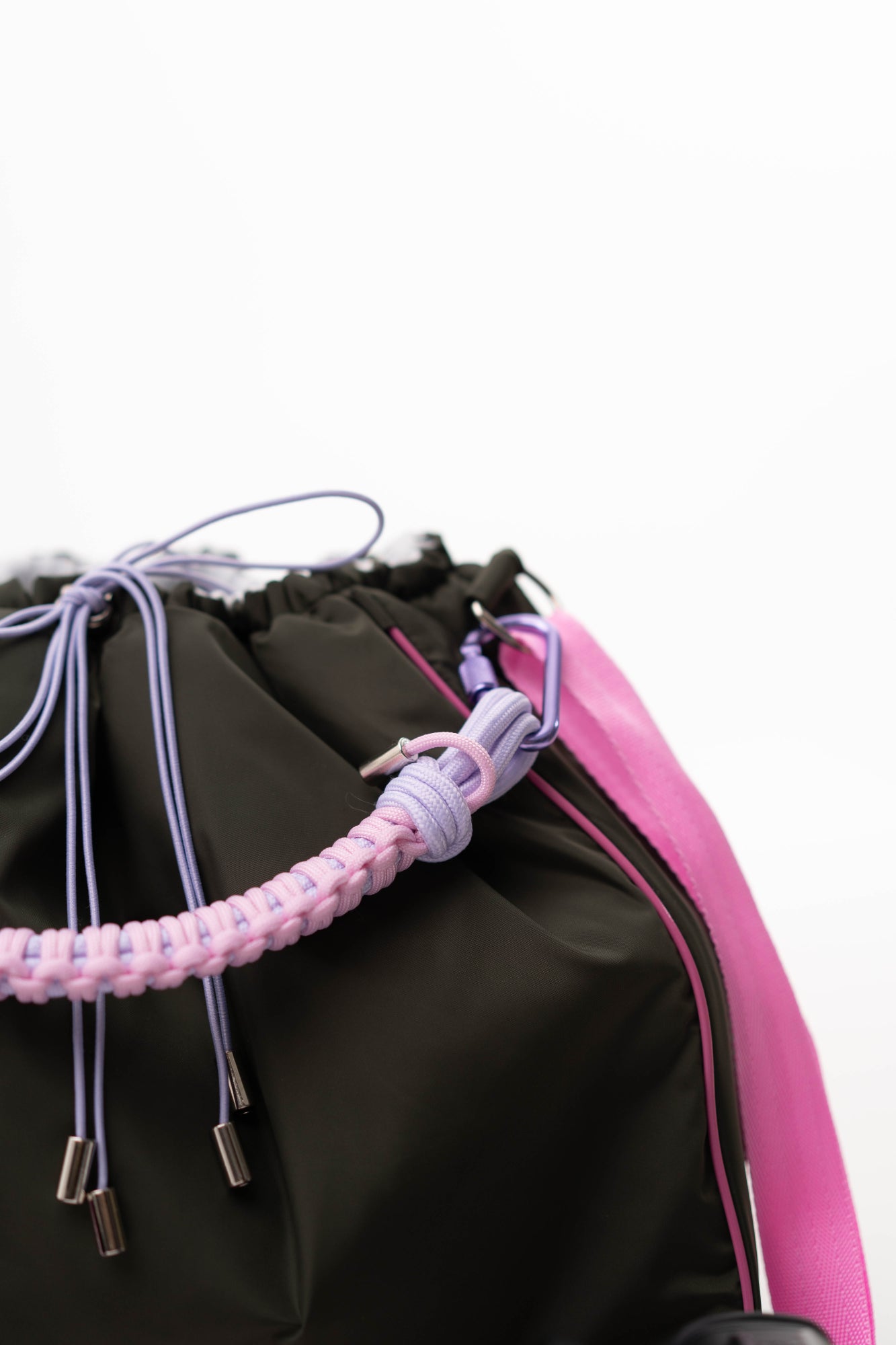 Close-up of the khaki Maxi Bubzi bag with a pink handle, purple drawstrings, and shoulder strap