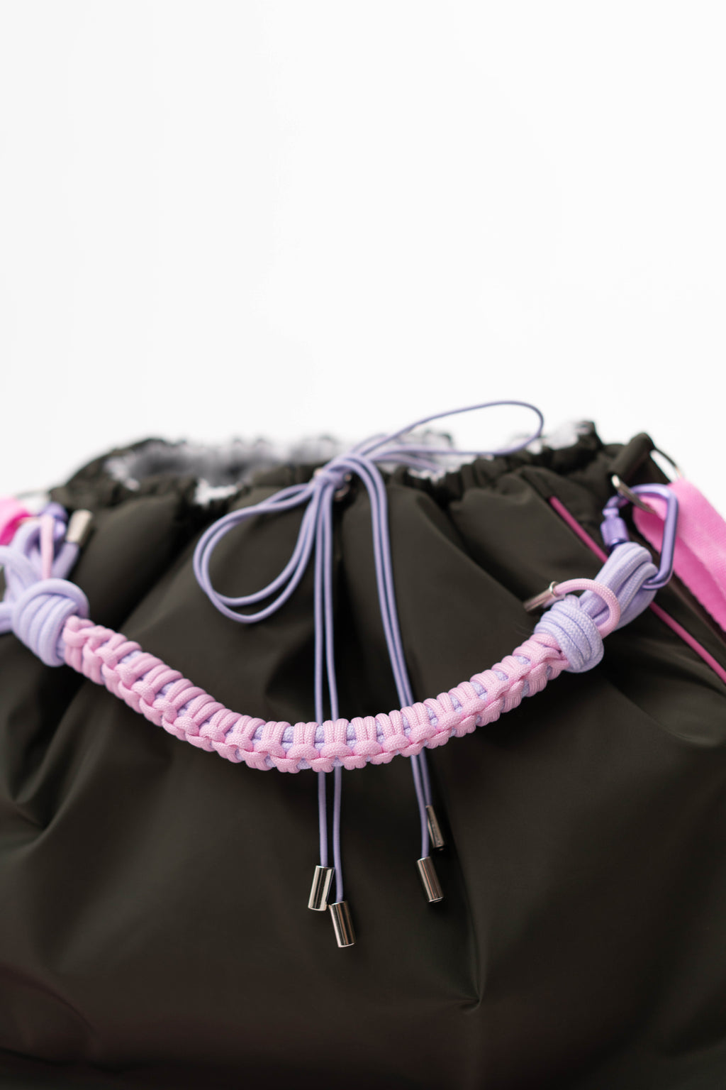 Detail view of the braided handle, drawstrings, and fabric of the khaki Maxi Bubzi bag