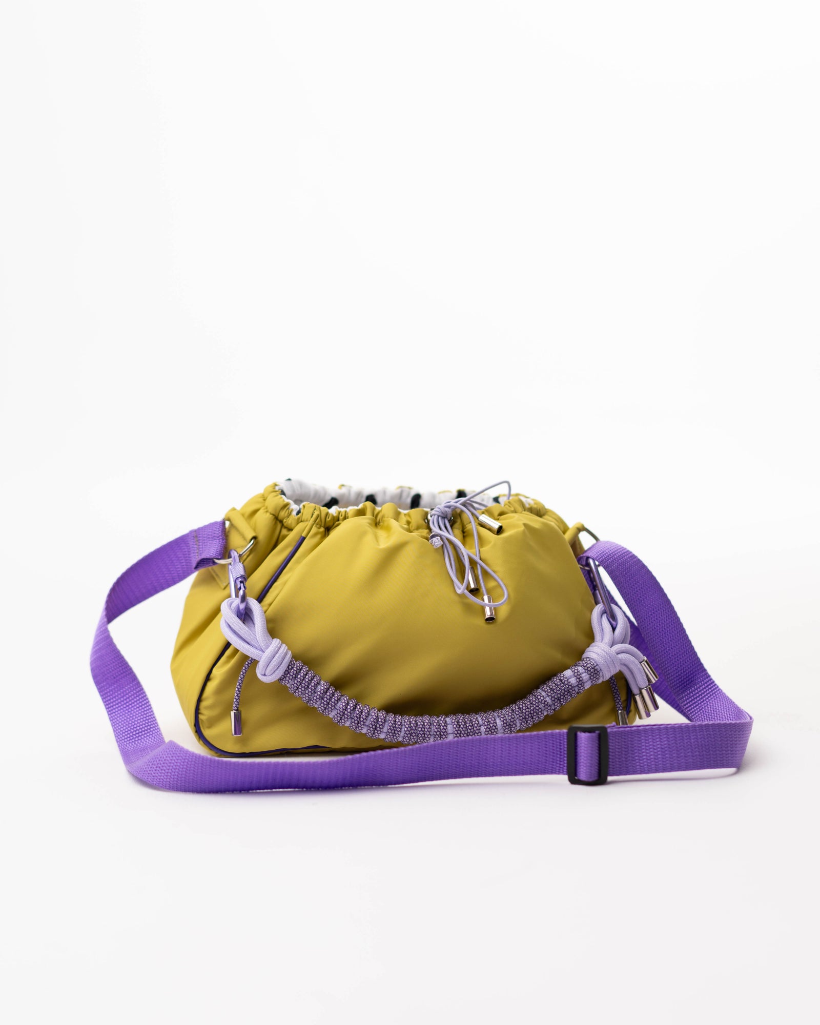Front view of the lime Mini Bubzi bag with purple strap, braided handle, and soft gathered opening