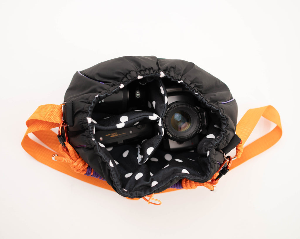 Black Mini Bubzi camera bag with padded compartments for a camera, lens, and accessories