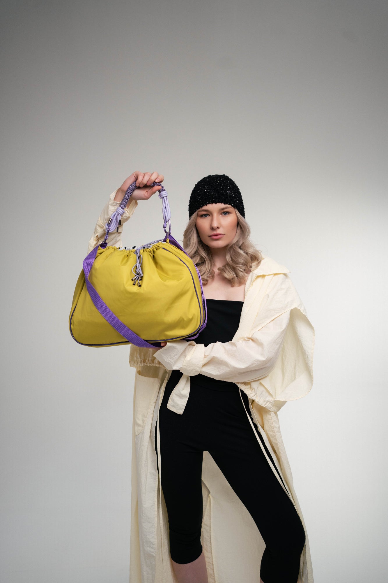 The model is posing with a lime Maxi Bubzi bag for the camera in the studio.