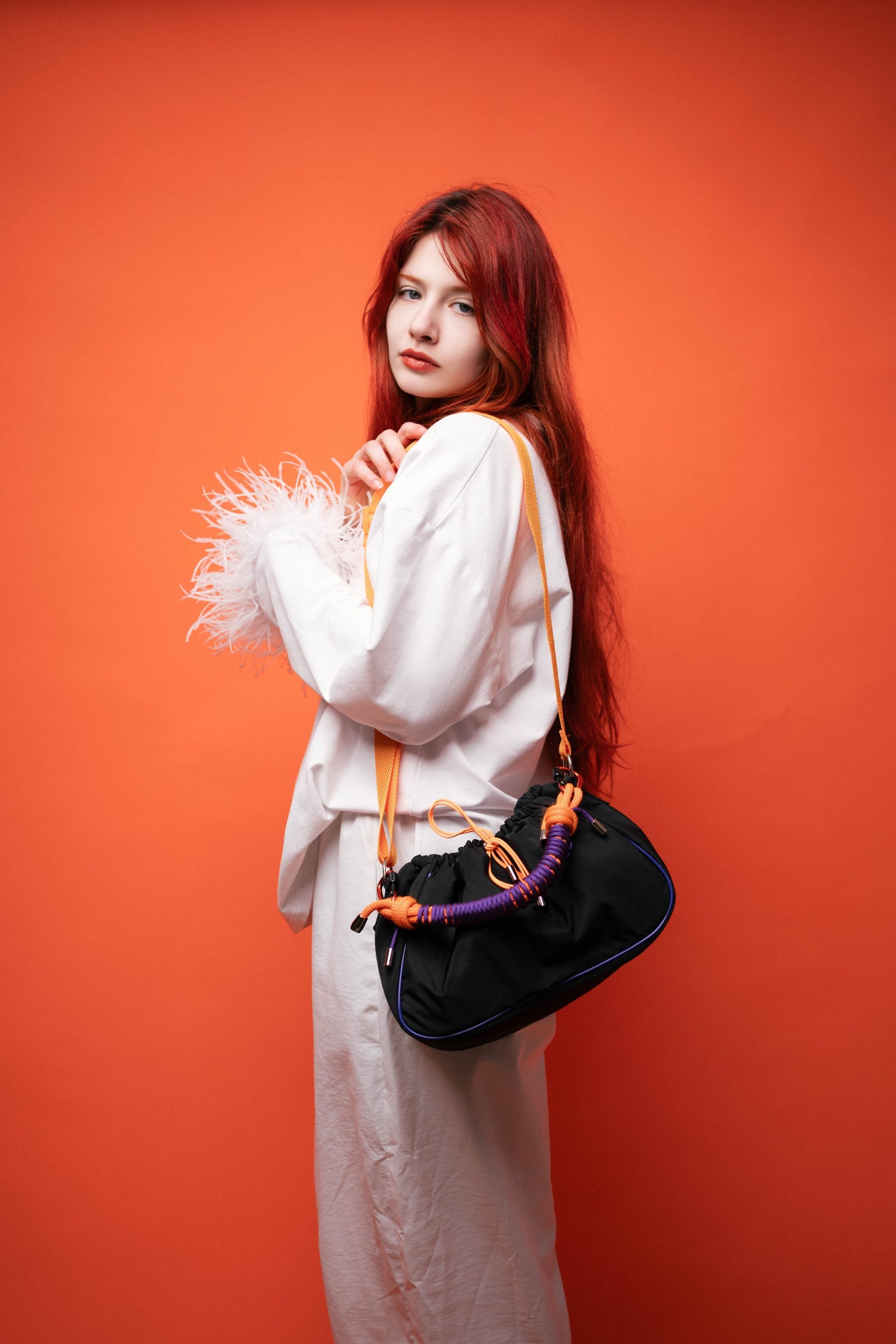Model posing with a black Mini Bubzi bag on a studio background