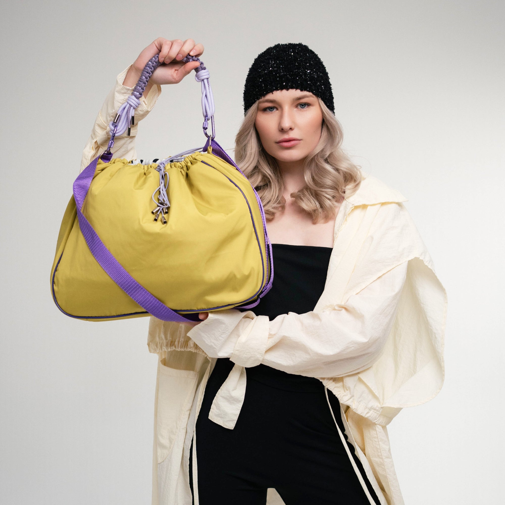 Model holding a lime Maxi Bubzi camera bag with purple strap