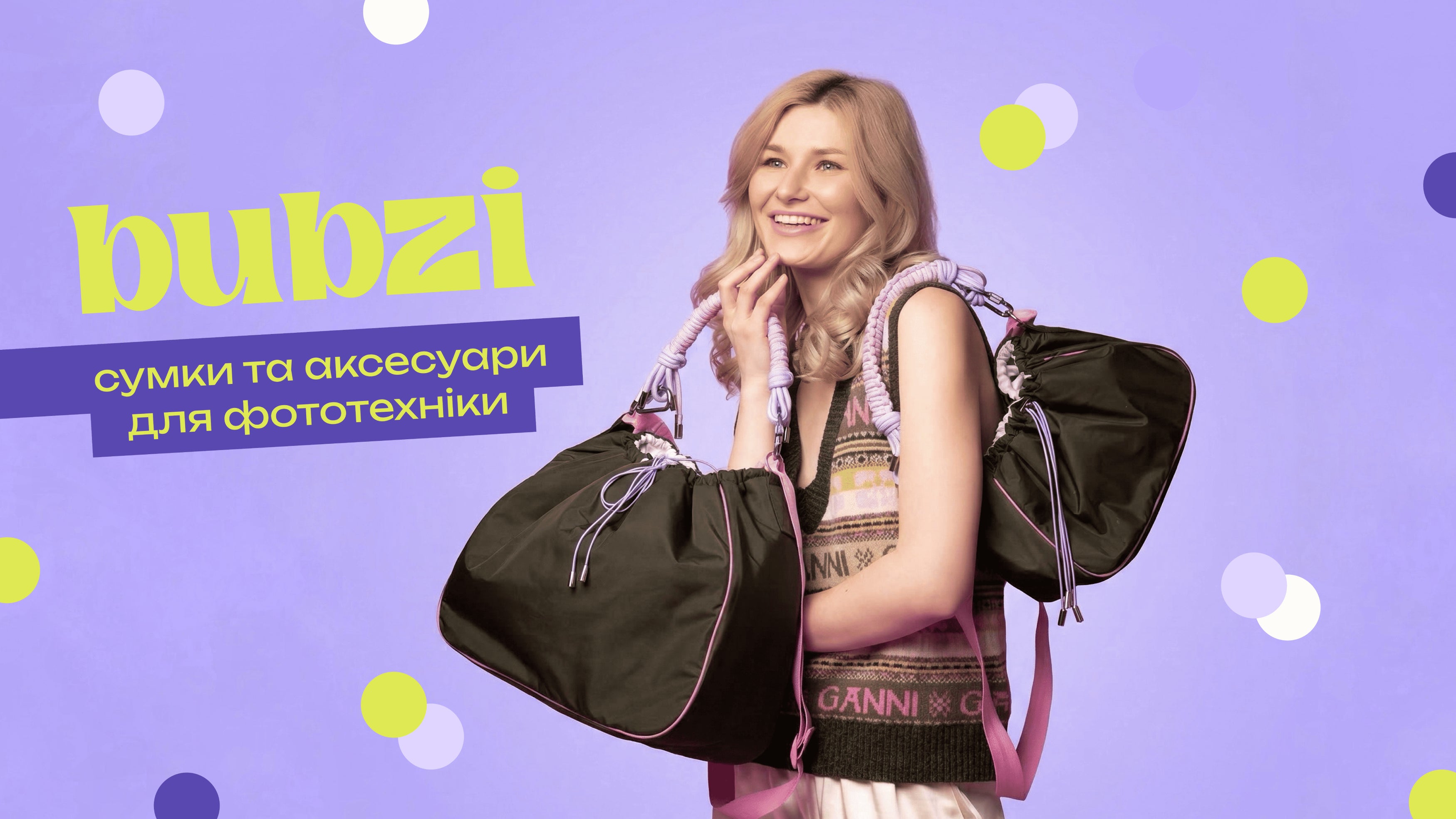 Model holding two black Bubzi camera bags on a purple background
